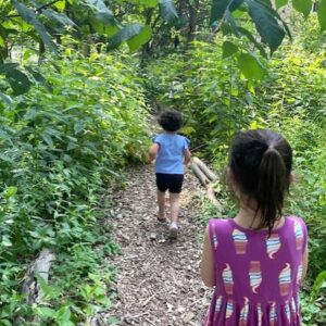 Young boy and girl walking on a nature trail.